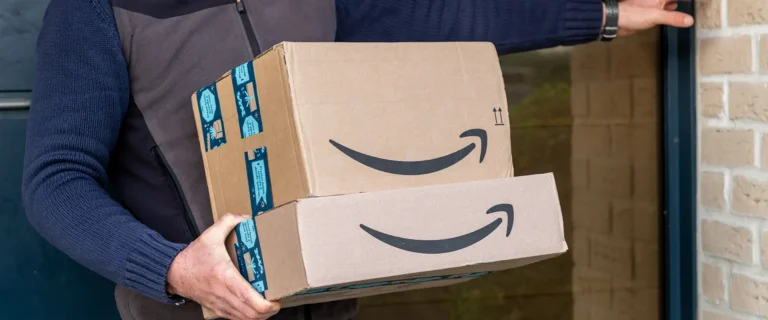 Individual holding 2 Amazon boxes